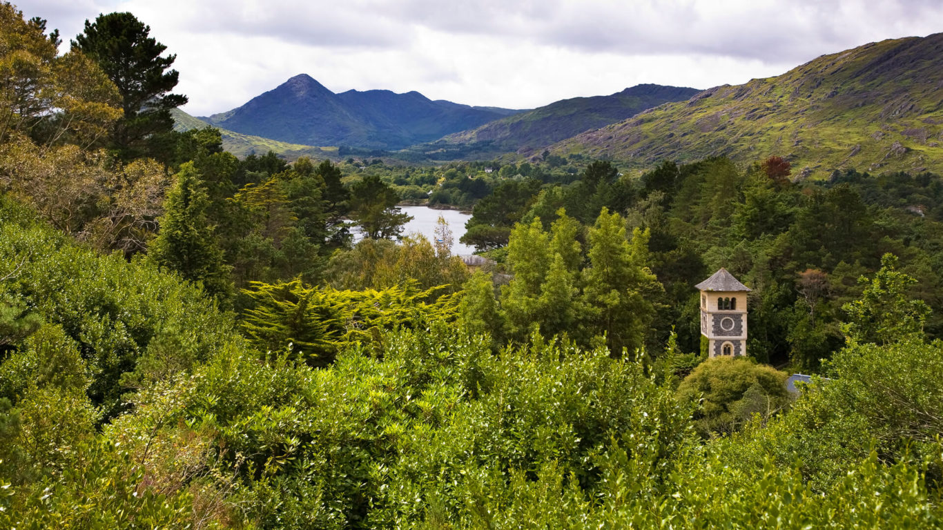 Serene mountain and forest view with a charming stone tower, inviting guests to a tranquil escape.