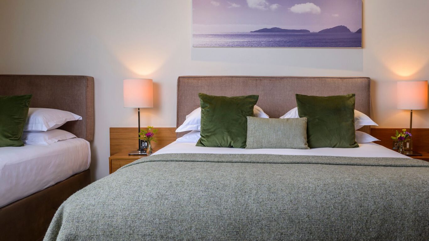 Luxurious hotel room with plush double bed, soft lighting, elegant décor, and scenic artwork, ensuring a restful stay.